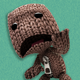A sad-looking Sackboy from LittleBigPlanet stands in a green void.